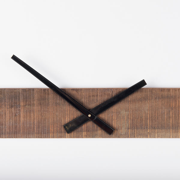 detail view of lack metal clock hands and wood accent - home decor